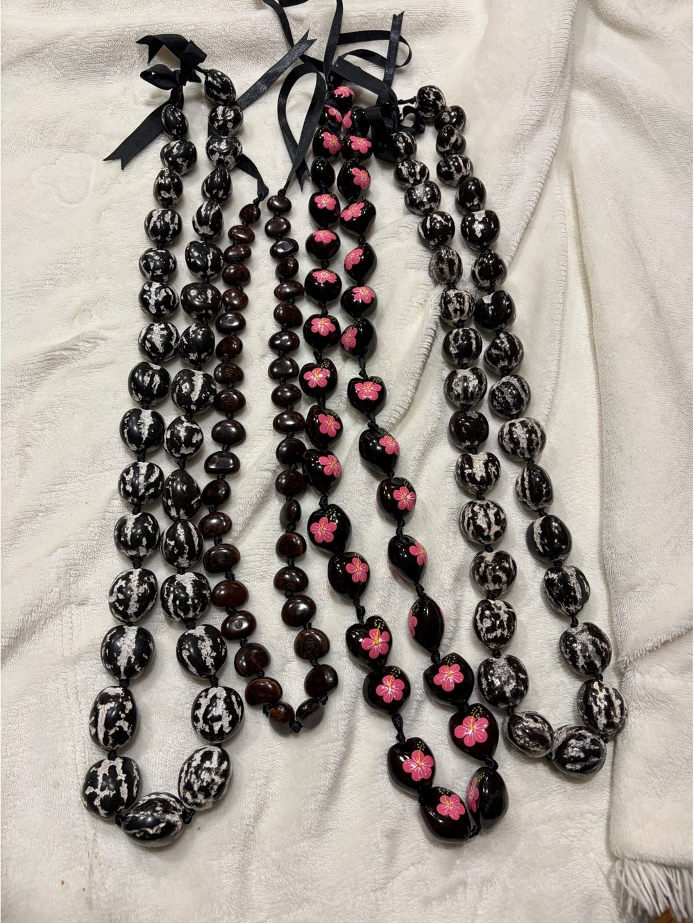 Set of 4 handcrafted Hawaiian kukui nut leis brown, 2 black / white multi, black